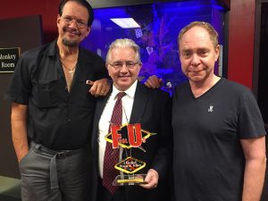Paul Gertner holding the FU Trophy with Penn and Teller